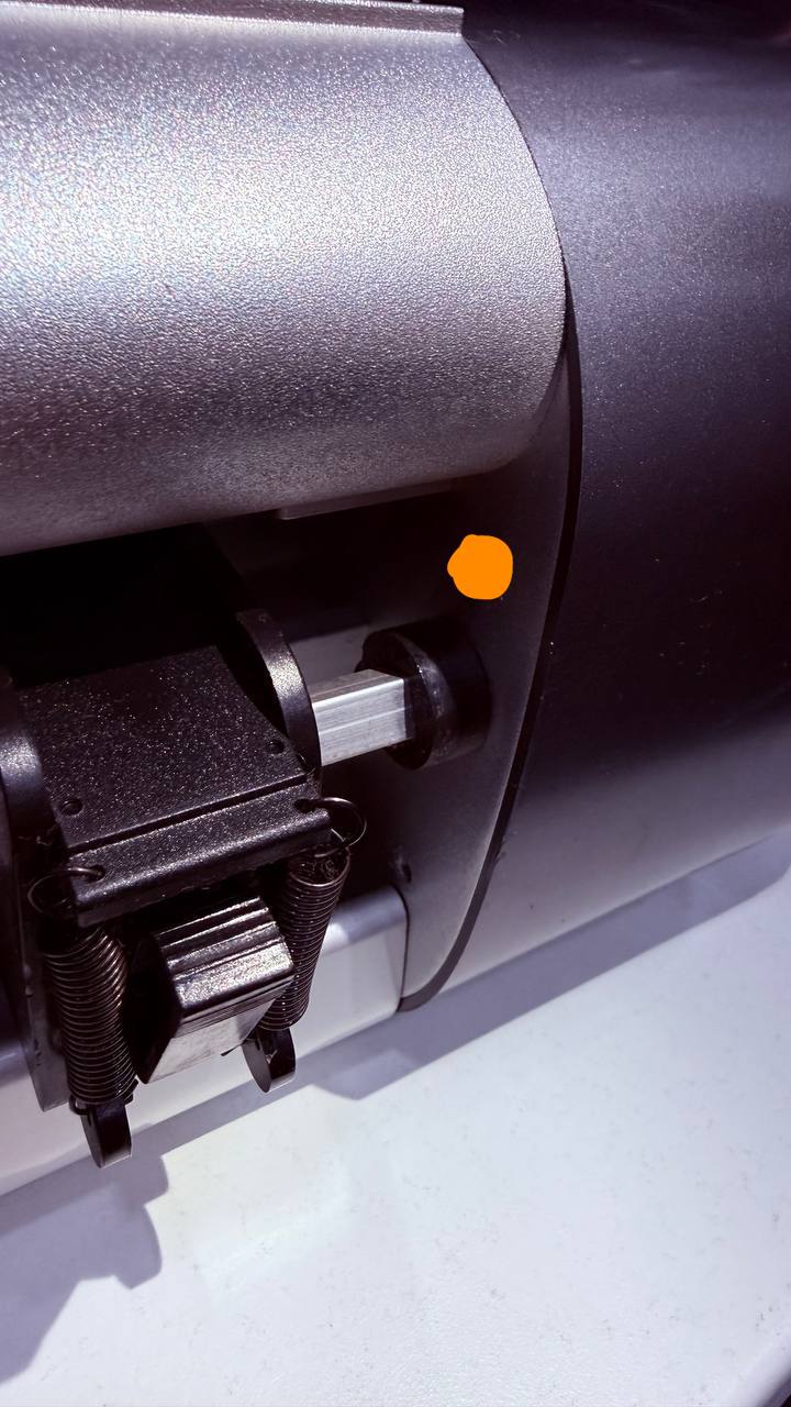 Переднее крепление правой боковины рядом с прижимным роликом